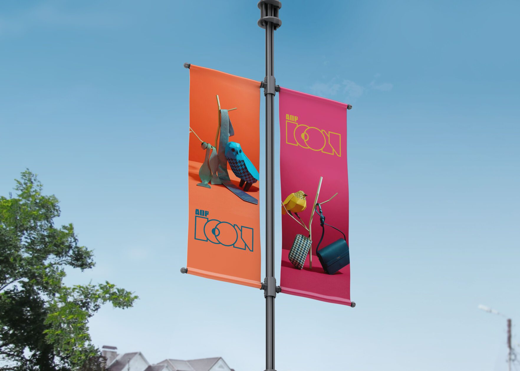 Bright orange and pink outdoor banners featuring the AOP ICON logo and stylised still life photography. Mounted on street poles.