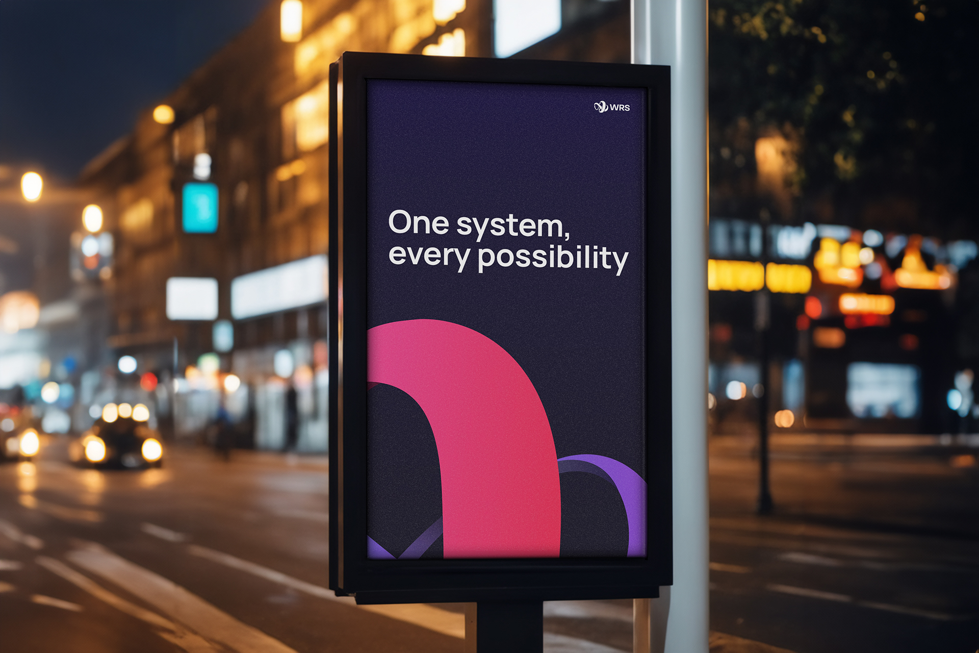 Urban digital billboard at night displaying the WRS tagline “One system, every possibility” with pink and purple brand arcs.