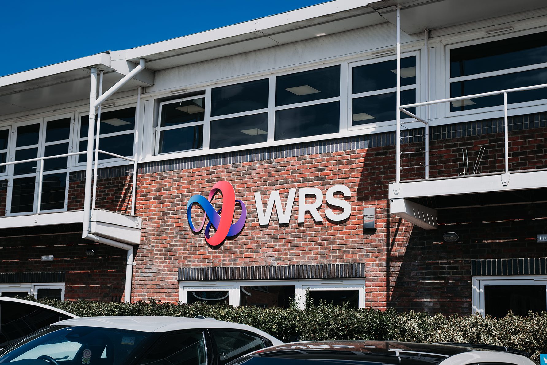 Exterior shot of the WRS building with the new red and blue logo mounted on a brick wall.